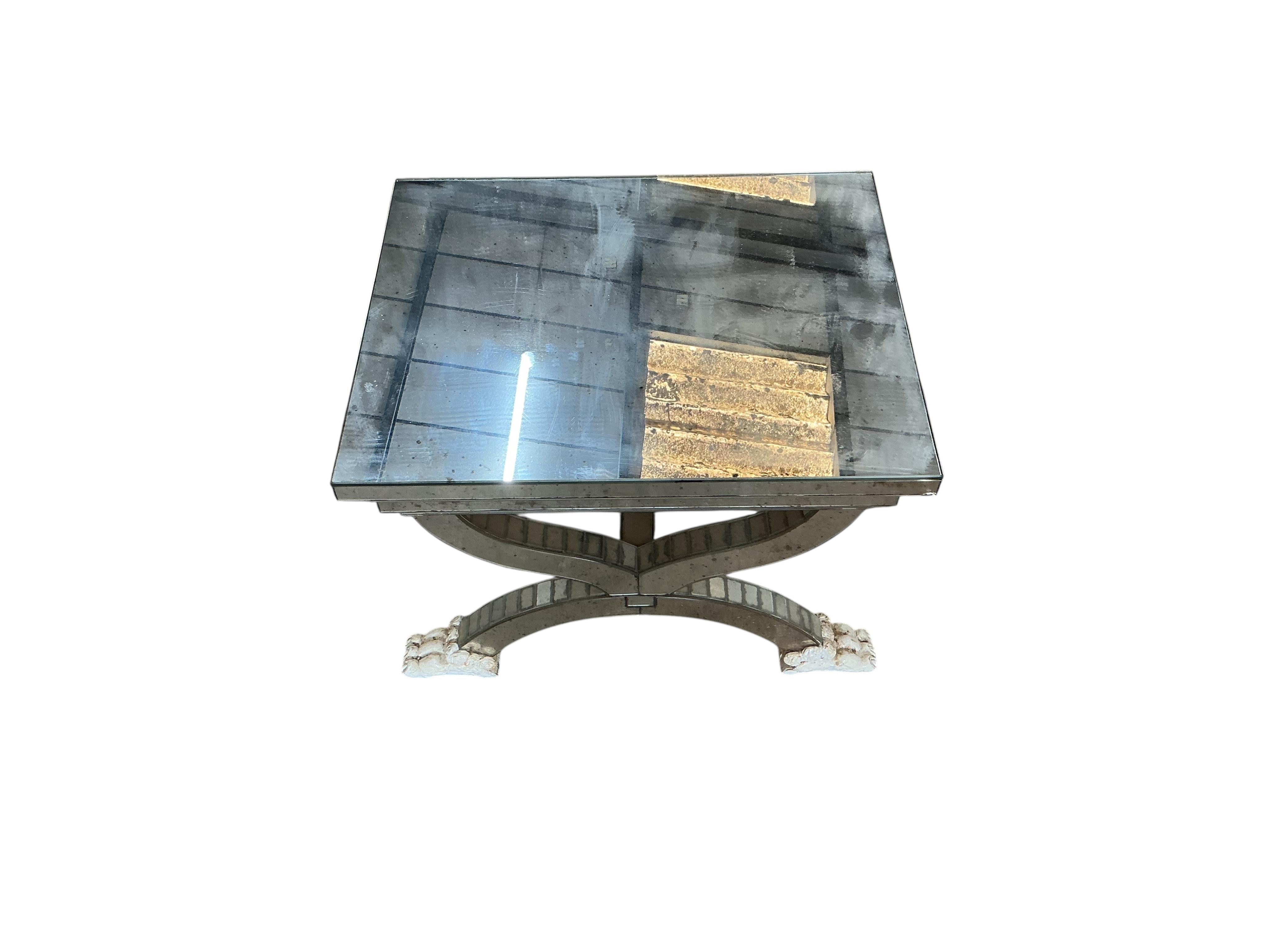 A mirror panelled X-framed lamp table, on four cream painted lion paw feet, width 56cm, depth 46cm, height 48cm